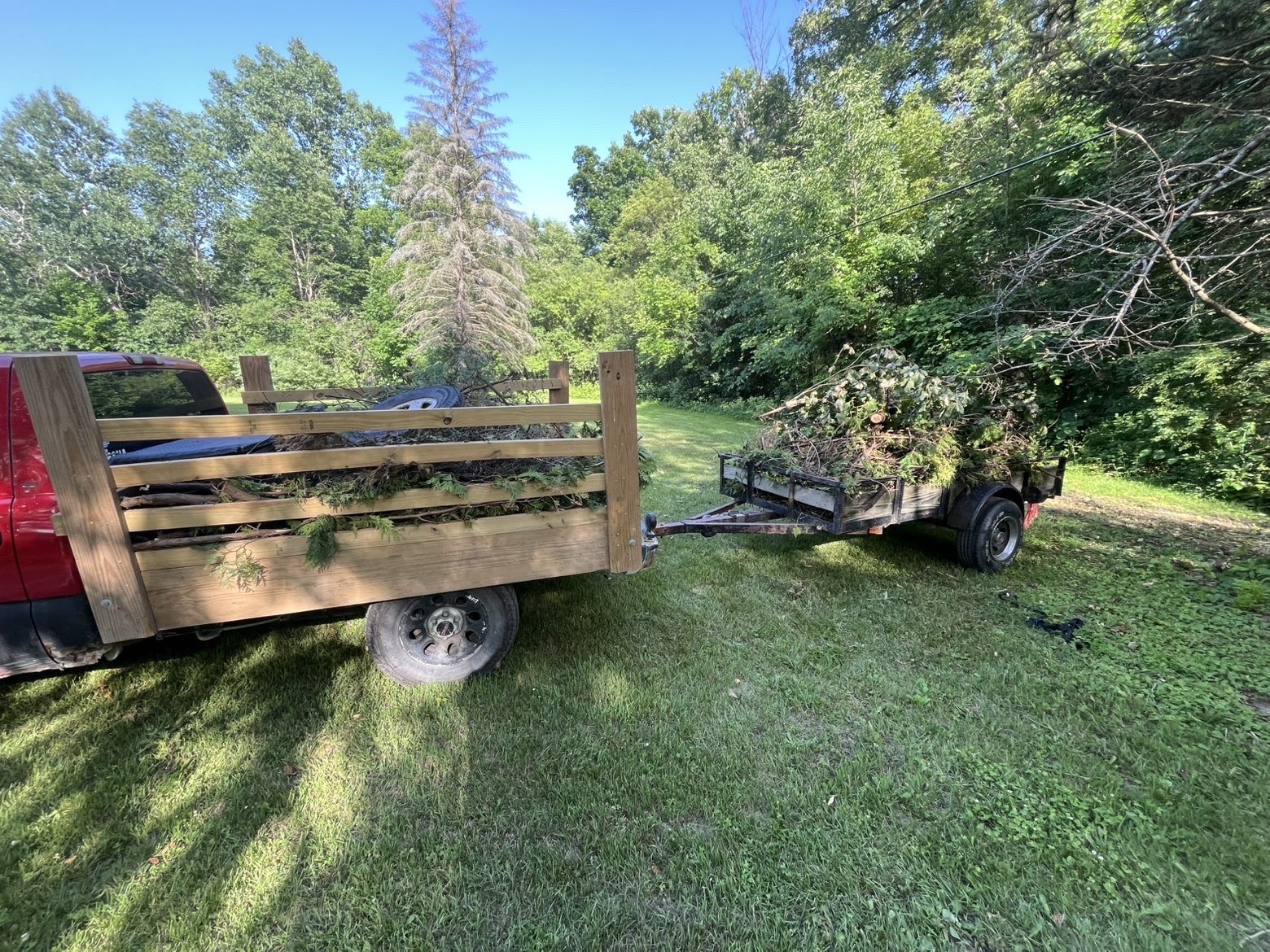 Truck and trailer loaded with brush and yard debris hauled away